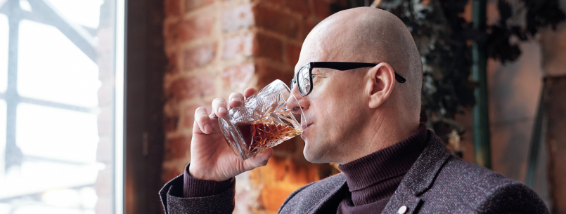 bald guy drinking whiskey